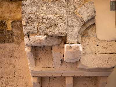 Sulla destra sono presenti invece delle mensole medievali compattate assieme ad altri antichi elementi in pietra di riuso per sorreggere il peso del balcone superiore